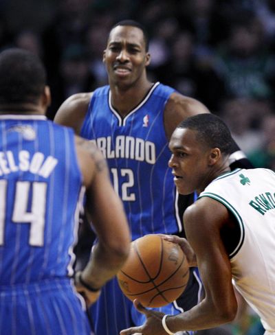 Boston point guard Rajon Rondo (right) dribbles between Orlando center Dwight Howard (center) and guard Jameer Nelson. (Associated Press)