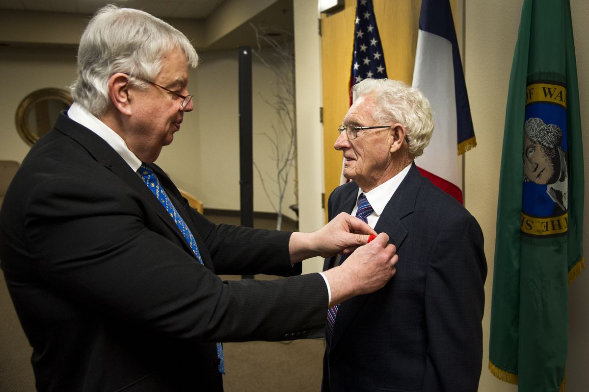 Jack Cowan, honorary consul of France, pins the French Legion of Honor medal on World War II veteran William H. McIntosh during a ceremony Saturday at Faith Bible Church in Spokane. (Colin Mulvany)