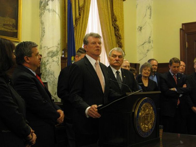 Gov. Butch Otter, flanked by state schools Supt. Tom Luna, left, and Senate Education Chairman John Goedde, right, hails this year's school reform bills before signing the third major one, SB 1184, into law on Friday. (Betsy Russell)