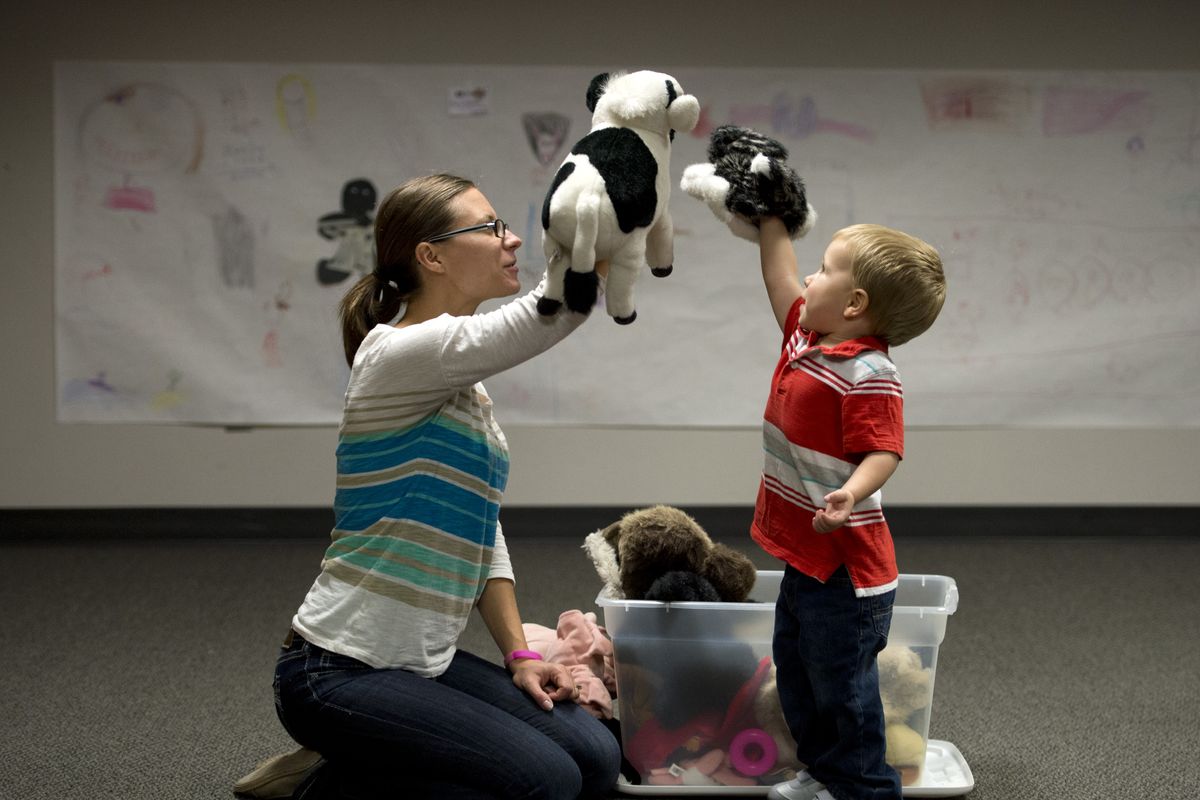 Alicia Green, 33, and her son Parker, 2, play with cow and cat hand puppets during Spokane Valley Library Toddler Play and Learn Storytime on Nov. 4. The library will be closed Monday through Nov. 16 for some main floor remodeling and carpet replacement. (Dan Pelle)