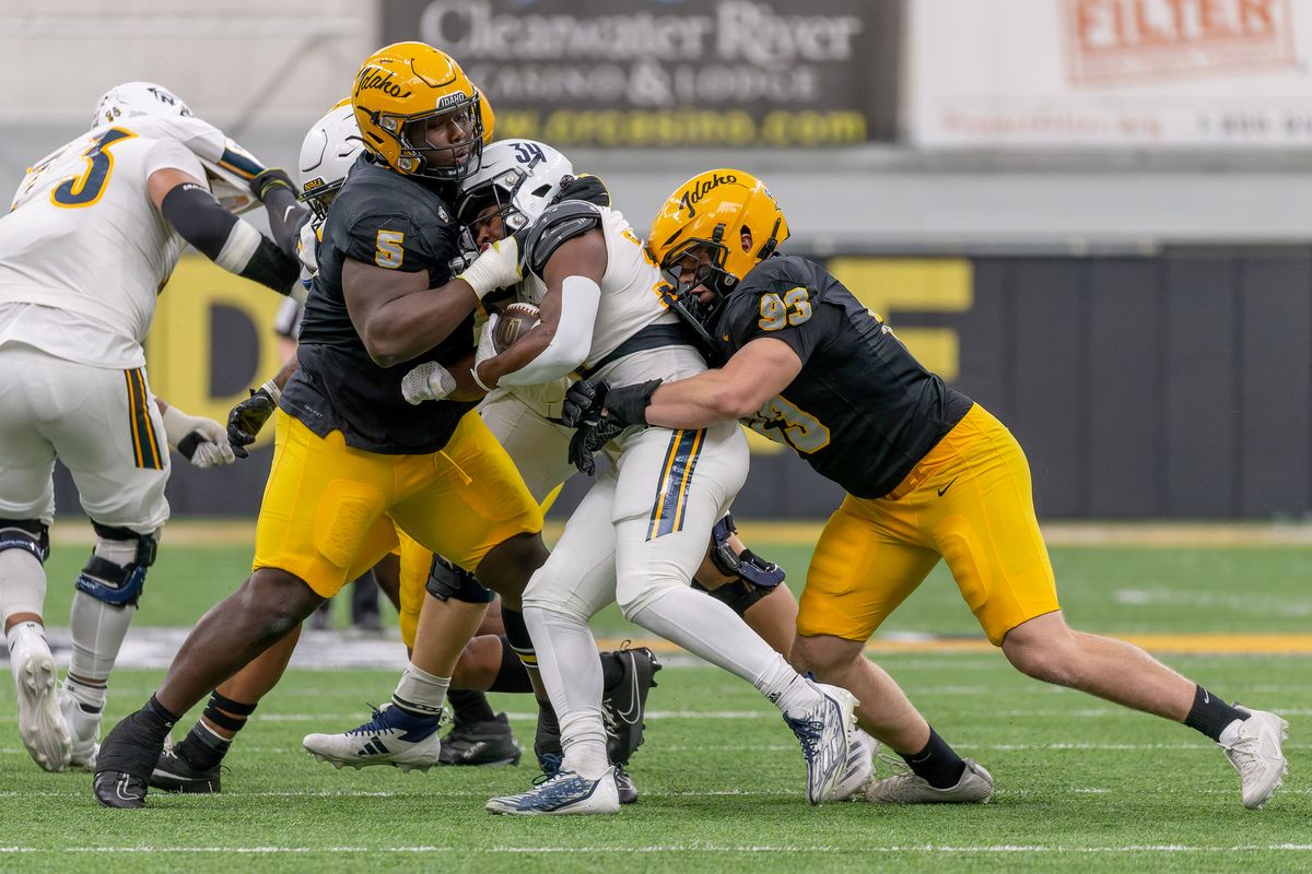 Idaho defensive linemen Jahkari Larmond (5) and Sam Brown (93) bring down Northern Arizona running back Seth Cromwell in the first half on Saturday, Oct. 5, 2024, at Kibbie Dome in Moscow Idaho.  (Geoff Crimmins/For The Spokesman-Review)