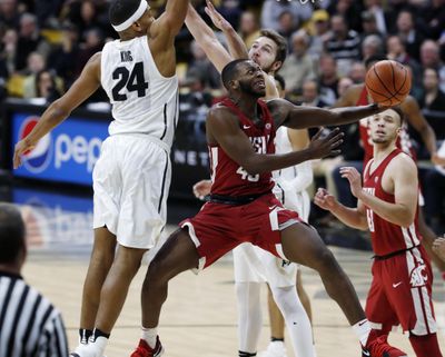 Washington State guard Kwinton Hinson drives the lane for a basket between Colorado guard George King, back left, and forward Lucas Siewert on Jan. 18 in Boulder, Colorado. (David Zalubowski / AP)