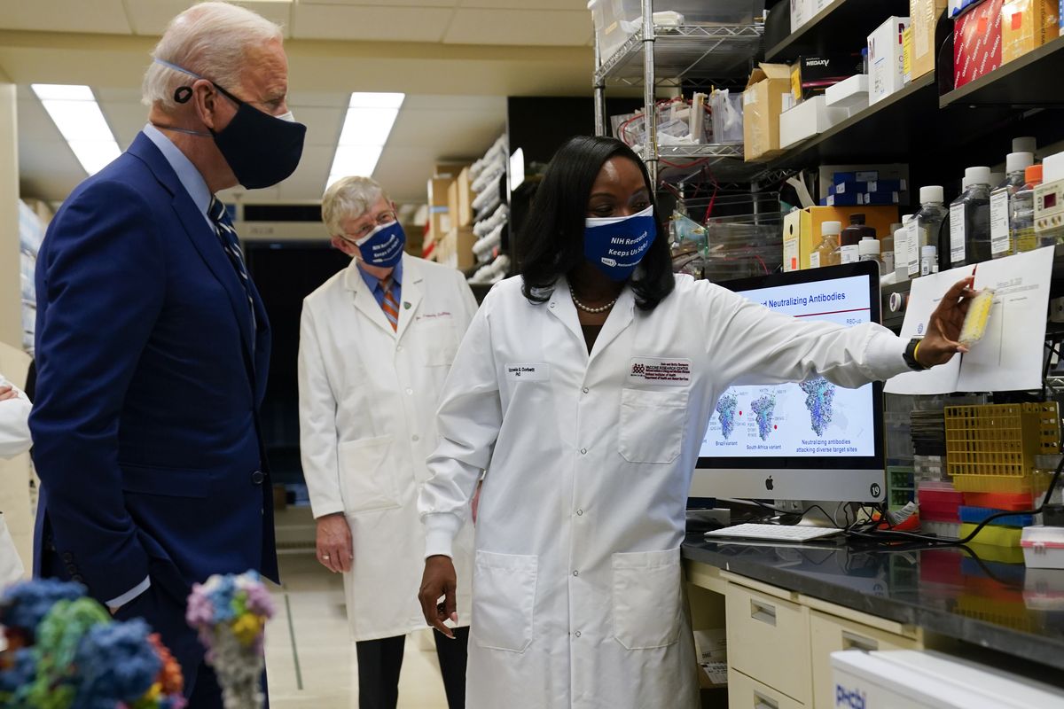 President Joe Biden listens as Kizzmekia Corbett, an immunologist with the Vaccine Research Center at the National Institutes of Health, right, speaks Thursday during a visit at the Viral Pathogenesis Laboratory at the NIH, in Bethesda, Md. NIH Director Francis Collins looks on.  (Evan Vucci)