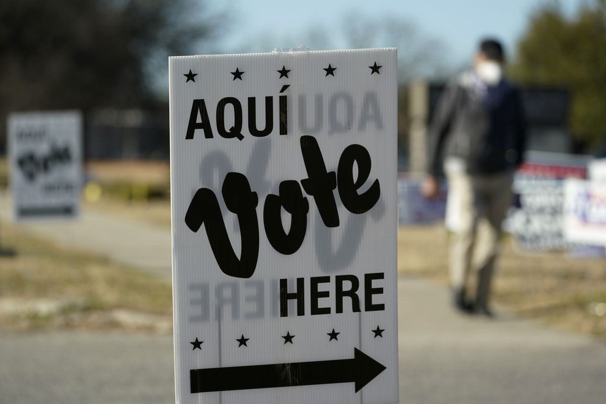 FILE - A man passes an early voting poll site, on Feb. 14, 2022, in San Antonio. Voters in Texas will usher in the midterm campaign season with primaries that will test just how far to the right the Republican Party will shift in a state where many in the GOP have already tightened their embrace of former President Donald Trump.  (Eric Gay)