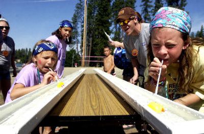 
Thalon Hansen, 10, right, of Spokane, struggles to beat Courtney Anderson, 11, of Spokane, in the race to blow a rubber duck the length of a trough Friday morning at Camp Goodtimes in Post Falls. 
 (Jesse Tinsley / The Spokesman-Review)