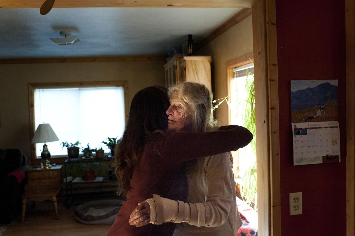 Jane Faller is embraced by her longtime friend Deb Anthes after she changed Faller’s arm bandage on Oct. 1 in Republic, Wash. Injured in a fall, Faller’s arm required daily care from Deb, who would visit her as Jane’s husband, Bob Faller, lay in hospice care. (Tyler Tjomsland / The Spokesman-Review)