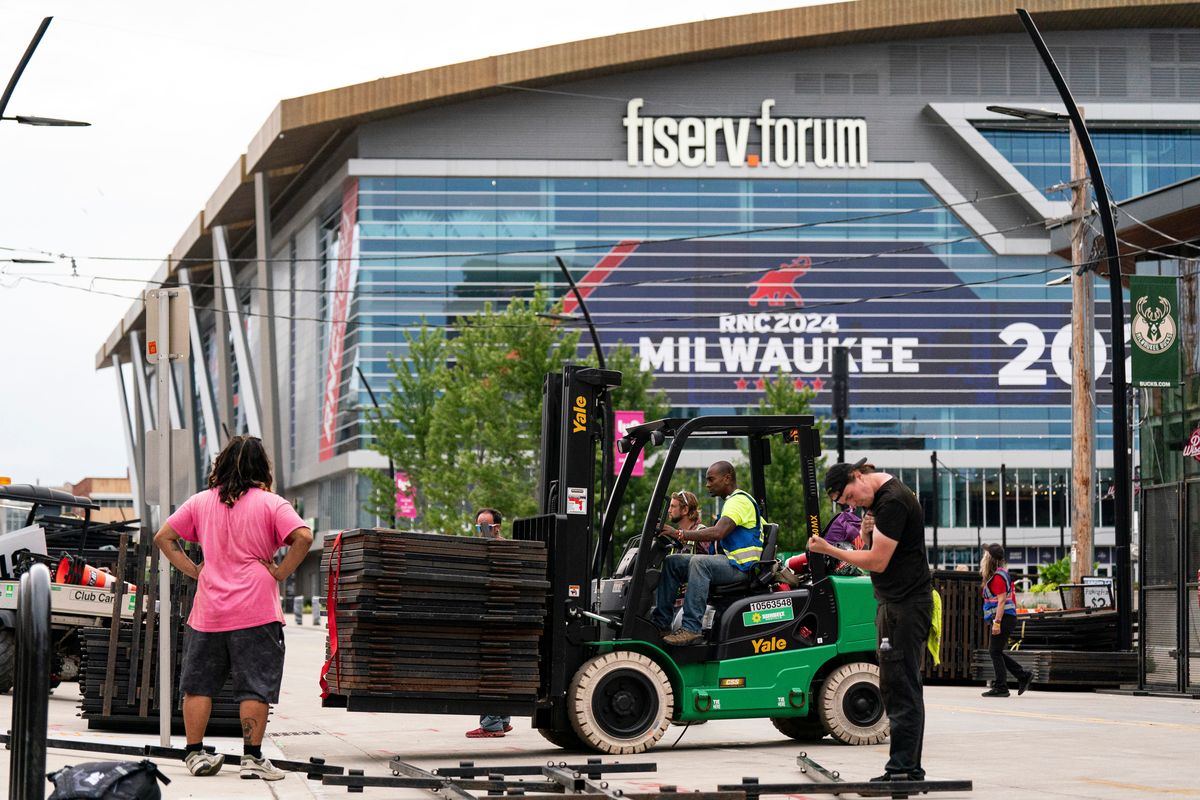 Workers install security fencing near the Fiserv Forum ahead of the Republican National Convention in Milwaukee.   (Al Drago/Photographer: Al Drago/Bloomberg)