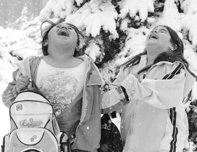 
Karla Arias, left, and Margarita Herrera, both second-graders at Central Elementary School, play in the snow at the end of the school Friday in Dodge City, Kan., as a storm moved through. 
 (Associated Press / The Spokesman-Review)
