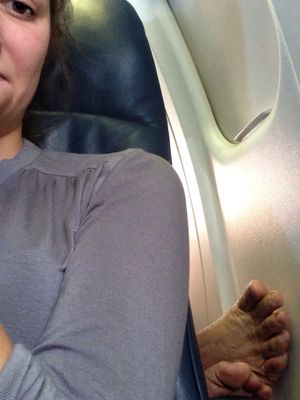 An airline passenger reacts to the bare feet of the person seated behind behind her. (Cheryl-Anne Millsap / photo by Cheryl-Anne Millsap)