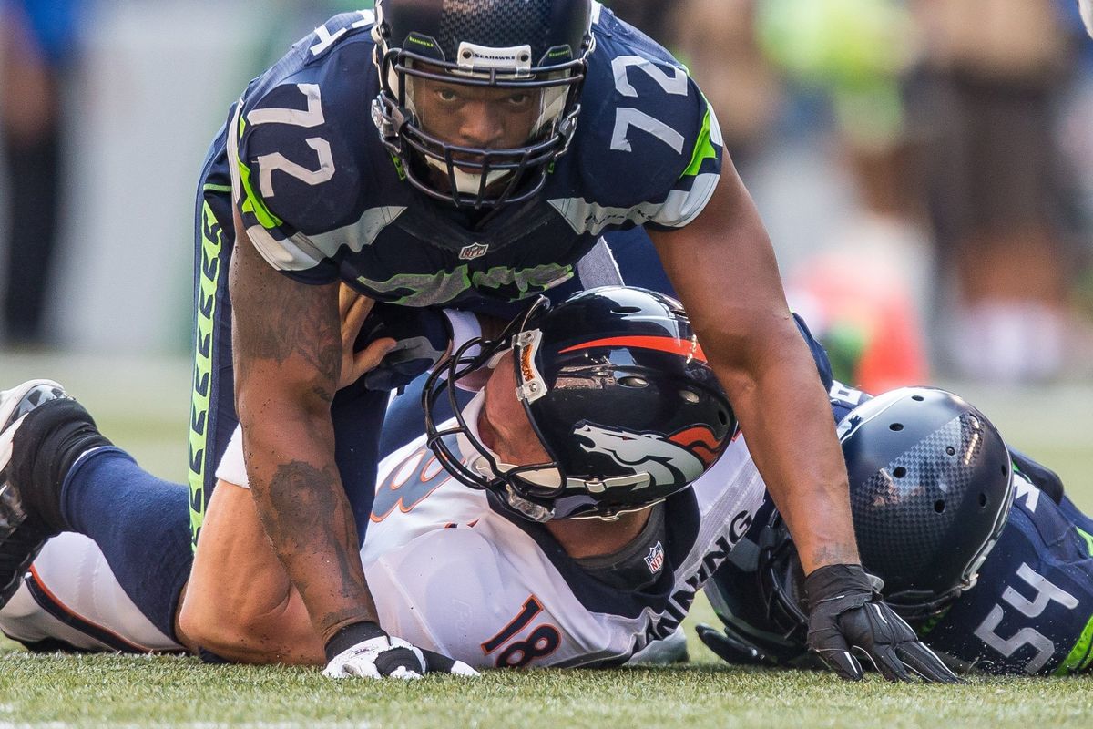 Seahawks’ Michael Bennett and Bobby Wagner, right, drop Broncos quarterback Peyton Manning just after he throws.