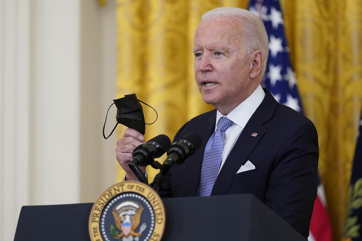 President Joe Biden holds a face mask as he announces from the East Room of the White House in Washington, Thursday, July 29, 2021, that millions of federal workers must show proof they