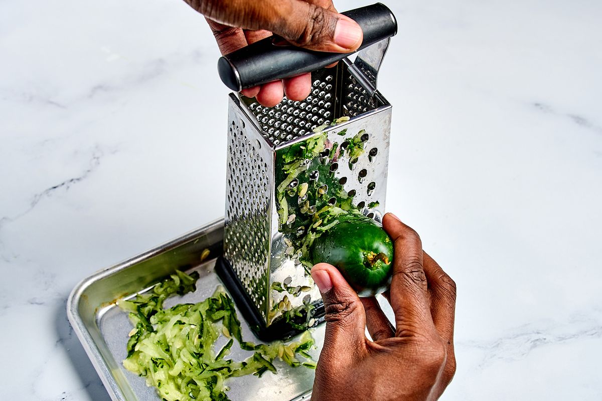 Grating cucumber for tzatziki.  (Peggy Cormary/For The Washington Post)