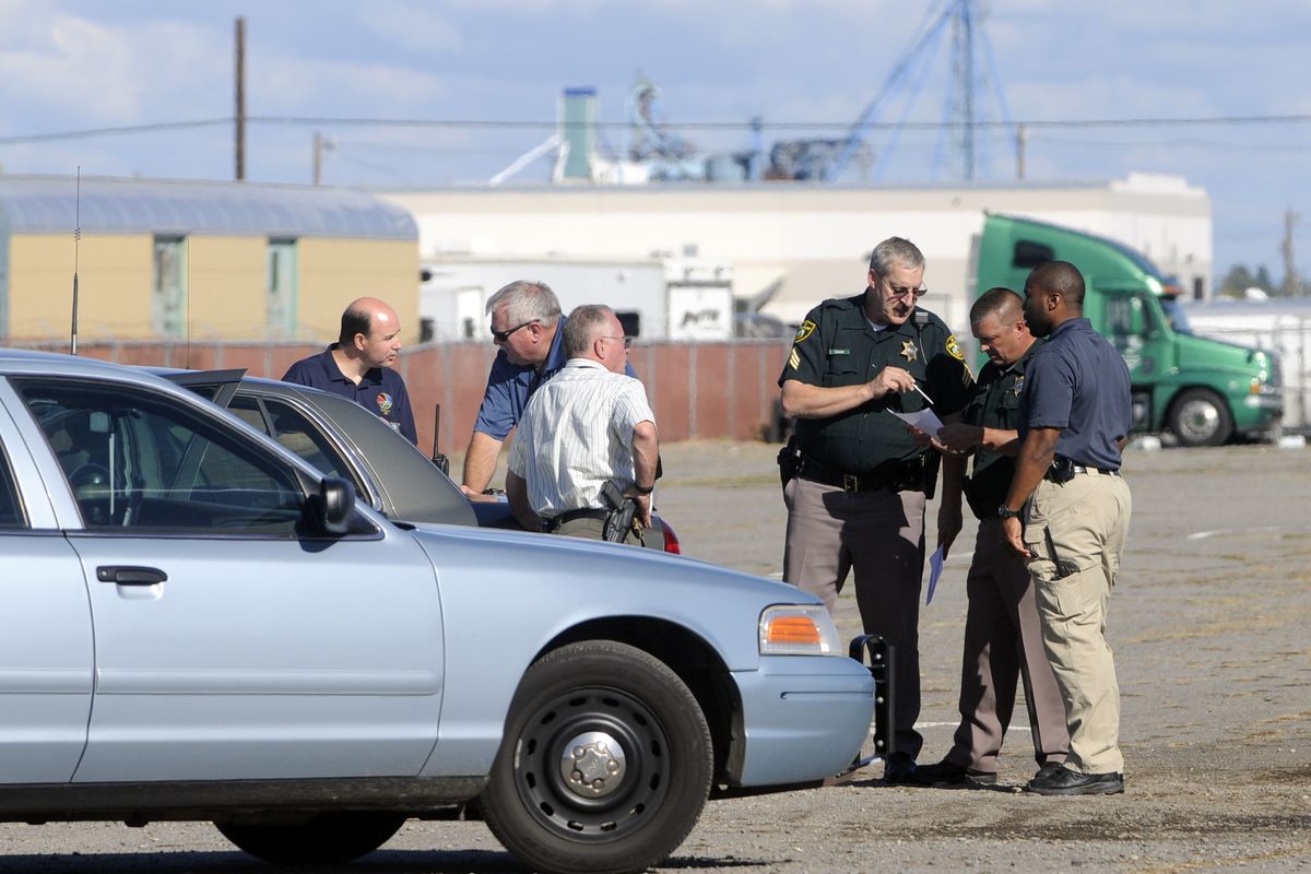 Officers from the Spokane County Sheriff’s Department confer in the parking lot outside the Spokane County Fair and  Expo Center  on Thursday following a report that  an Eastern State Hospital patient  had walked away from a field trip. (Jesse Tinsley / The Spokesman-Review)