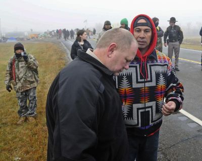 In this Oct. 26, 2016 file photo, Morton County Sheriff Kyle Kirchmeier, front, listens to Brian Wesley Horinek, of Oklahoma, outside the New Camp on Pipeline Easement in North Dakota. Kirchmeier has been the face of law enforcement through the protest to block construction of the four-state Dakota Access oil pipeline designed to carry oil from western North Dakota to Illinois. (Tom Stromme / AP)
