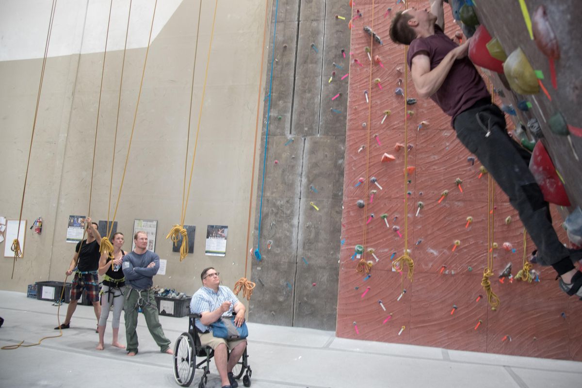 Josh Jackman, left, uses a laser pointer to direct Aaron Dubbels. In 2007 Jackman was hit by a drunk driver nearly dying. Since then, Jackman has trained several generations of climbers in the Spokane area. (Eli Francovich / The Spokesman-Review)