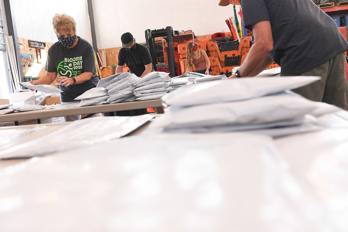 Judy Colenso, left, who said she has volunteered for Bloomsday for more than 30 years, applies shipping labels to packaged Bloomsday finisher T-shirts last Friday at Bloomsday headquarters in West Central. (Tyler Tjomsland/THE SPOKESMAN-REVIEW)