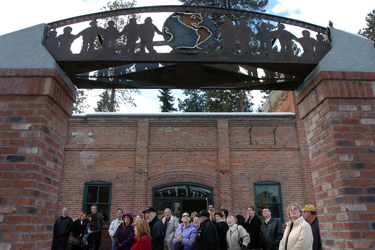 A crowd admires the ironwork sculpture that spans the entrance to the Human Rights Education Institute in Coeur d’Alene during the building’s dedication in 2005. (File)