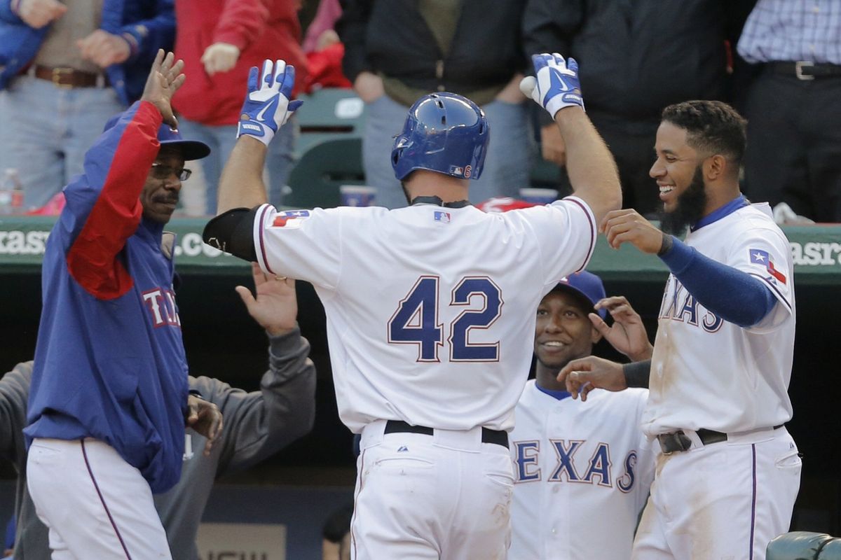 The Rangers' Kevin Kouzmanoff, center, is congratulated after his second-inning solo home run on Tuesday.