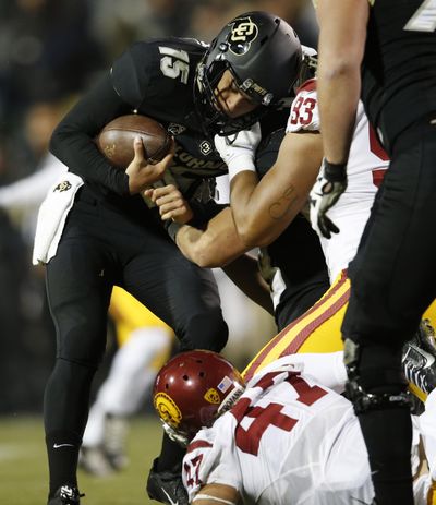 Colorado quarterback Cade Apsay, left, is sacked by Southern California defensive end Greg Townsend Jr., top right, and linebacker Scott Felix during the second half of an NCAA college football game Friday, Nov. 13, 2015, in Boulder, Colo. Southern California won 27-24. (AP Photo/David Zalubowski) ORG XMIT: CODZ114