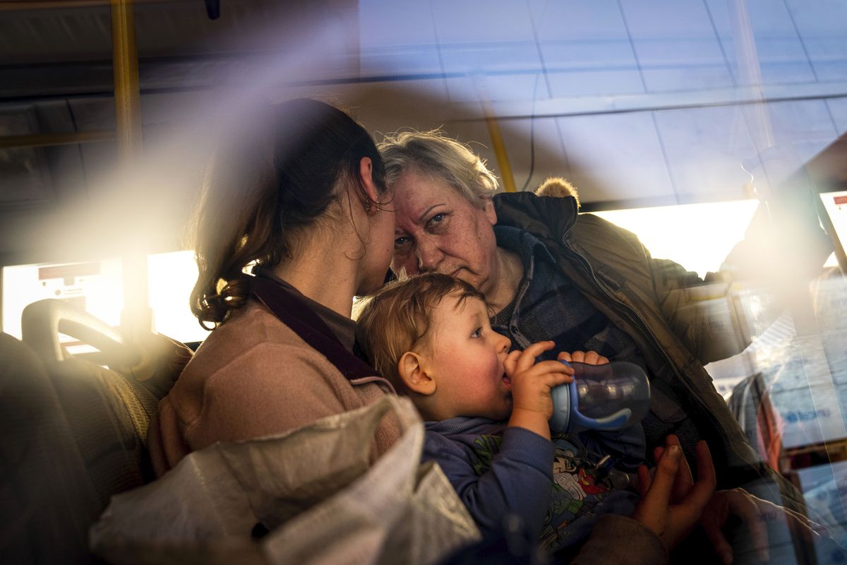 FILE - People with children wait after arriving from the Ukrainian city of Mariupol at a center for displaced people in Zaporizhzhia, Ukraine, May 3, 2022. With the evacuation of some civilians from a sprawling steel mill besieged by Russian forces, attention is turning to the fate of hundreds of Ukrainian troops still inside after weeks in the warren of underground tunnels and bunkers.  (Evgeniy Maloletka)