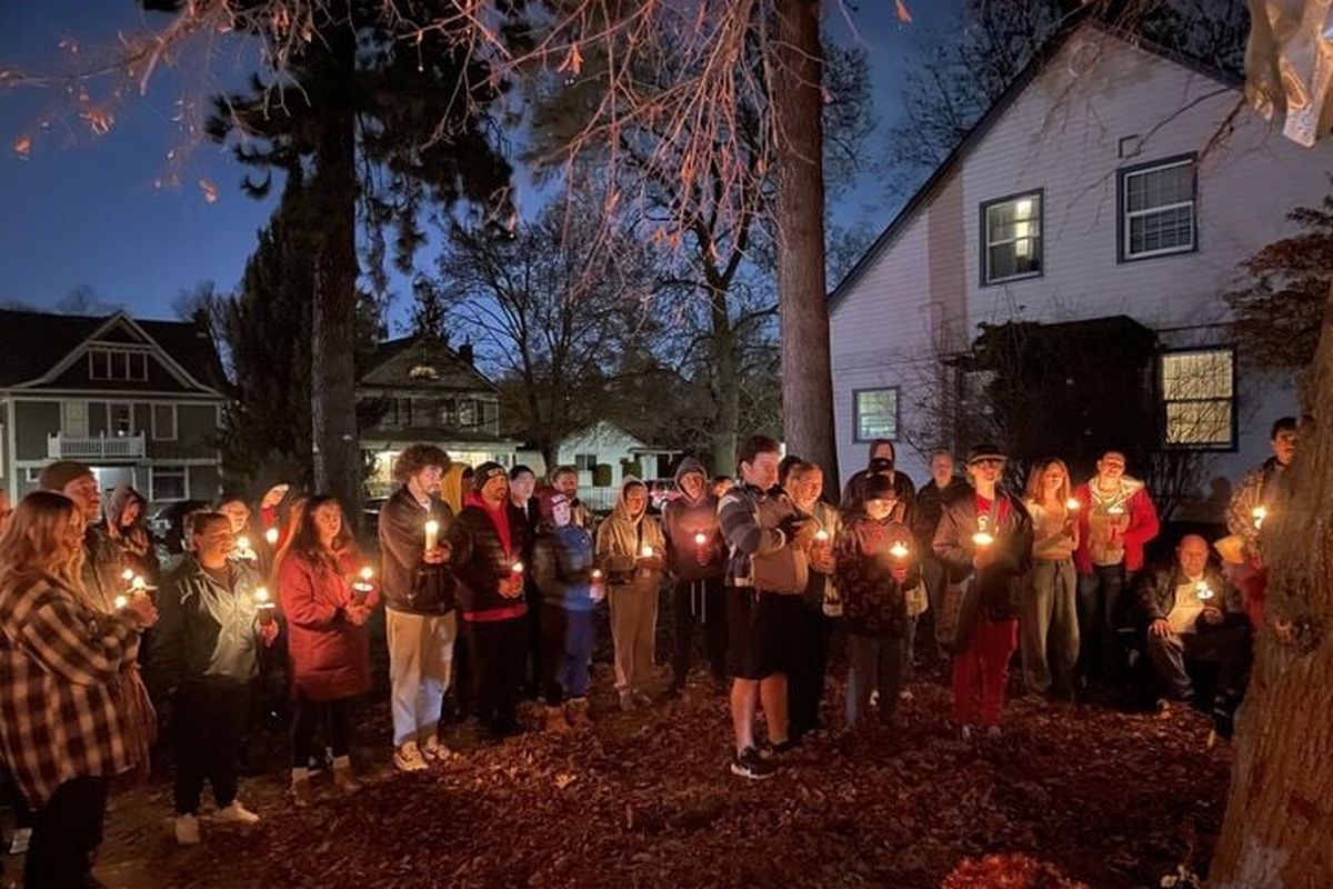 Eric Rideout’s friends and family members gather for a candlelight vigil Friday at the corner of Walnut Street and Eighth Avenue where Rideout died in a crash Nov. 17.  (Garrett Cabeza / The Spokesman-Review)