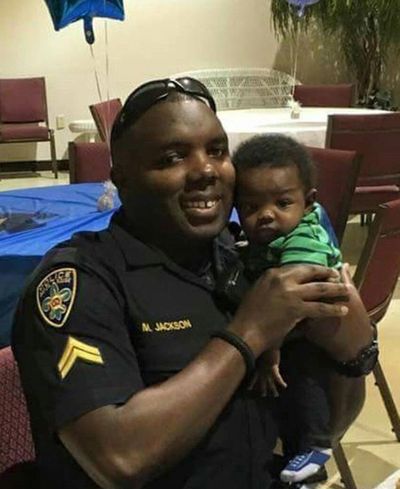In this  photo provided by Trenisha Jackson, her husband, Baton Rouge police Officer Montrell Jackson, holds his son Mason at a Father’s Day event this year for police officers in Baton Rouge, La. Montrell Jackson and two other Baton Rouge law enforcement officers investigating a report of a man with an assault rifle were killed Sunday, less than two weeks after a black man was fatally shot by police here in a confrontation that sparked nightly protests that reverberated nationwide. (Courtesy of Trenisha Jackson via AP)