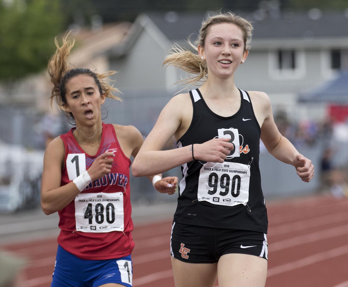 Lewis and Clark’s Katie Thronson smiles as she holds off a late charge from Eisenhower’s Erica Simison during the State 4A girls 3,200-meter run Saturday in Tacoma. (Patrick Hagerty / For The Spokesman-Review)