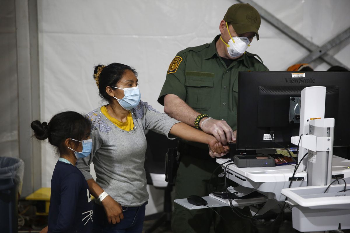 A migrant and her daughter have their biometric data entered at the intake area of the Donna Department of Homeland Security holding facility, the main detention center for unaccompanied children in the Rio Grande Valley, on Tuesday in Donna, Texas.  (Dario Lopez-Mills)
