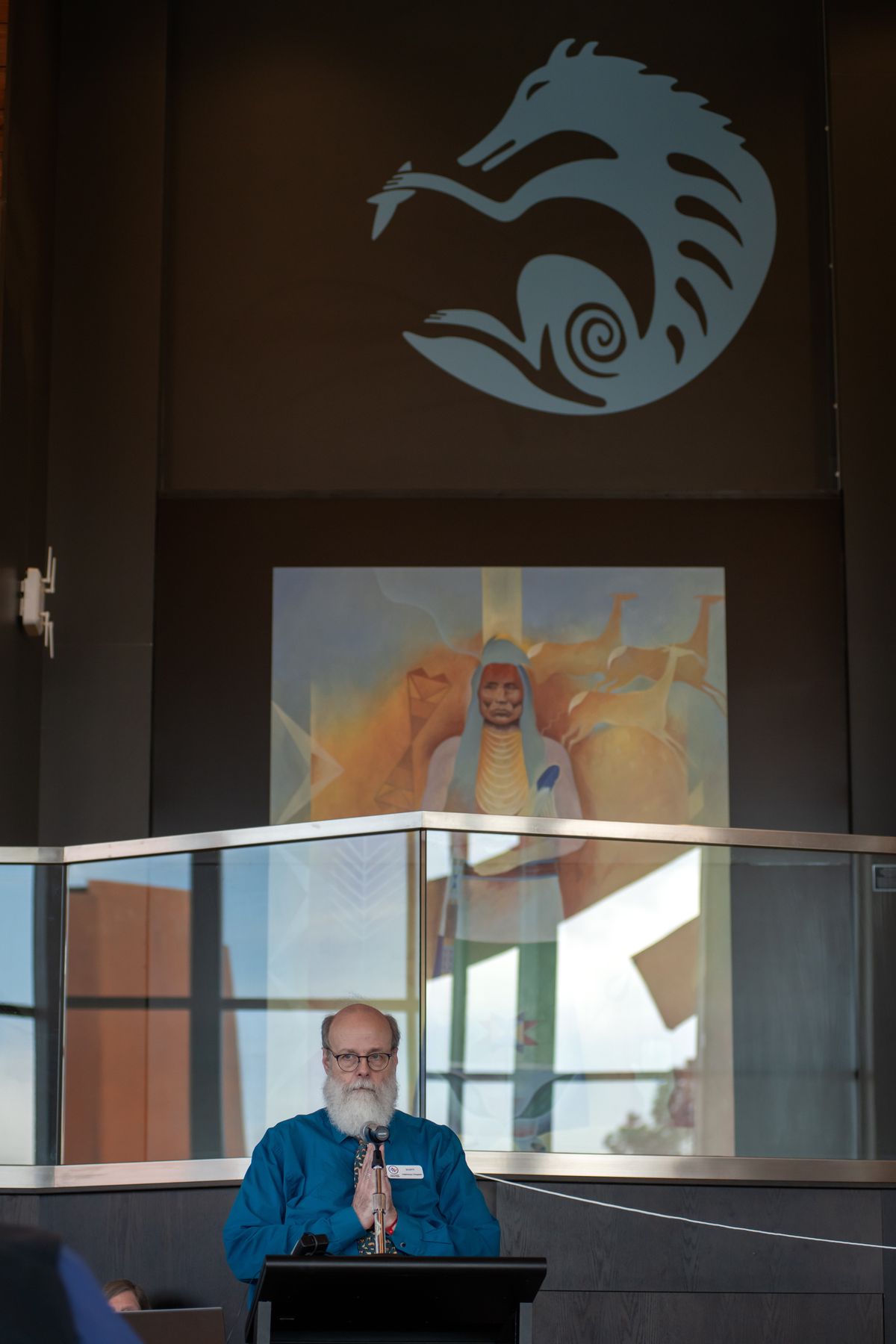 Scott Campbell, center, the veterinary chaplain for WSU’s College of Veterinary Medicine, speaks at the Celebration of Life &amp; Remembrance for Our Companion Animals ceremony on Saturday, April 13, 2024, at the Elson S. Floyd Cultural Center on the Washington State University campus in Pullman. Behind him is an icon image of a coyote created by artist David Kendall, and a painting by artist Nakia Williamson-Cloud. The event is held several times a year. (WSU College of Veterinary Medicine/Ted S. Warren)  (WSU College of Veterinary Medicine/Ted S. Warren)
