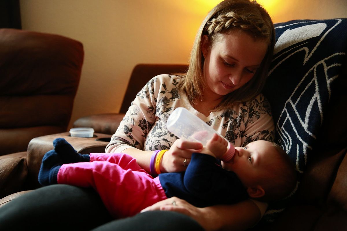 Jesi Paschen feeds daughter Radlee, 7 months, breast milk from a local donor at her home near Sumas, in Whatcom County, Washington. Paschen breastfed her first daughter but was unable to do the same for Radlee because of medications she was prescribed to treat a blood clot after the birth.