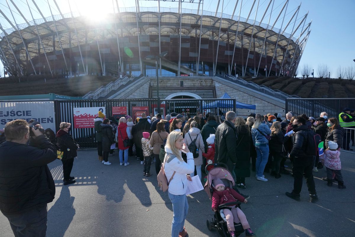 Hundreds of refugees from Ukraine wait in line in Warsaw, Poland, on Saturday to apply for Polish ID numbers that will entitle them to work, free health care and education, at a special application point at the National Stadium.  (Czarek Sokolowski)