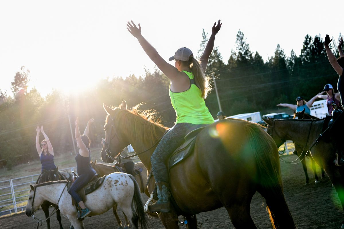 Participants soak up the sun as they preform breathing exercises during Sunset Cowgirl Yoga led by Briana Randall on Tuesday, July 30, 2019, at Sunset Arena in Cheney. (Tyler Tjomsland / The Spokesman-Review)