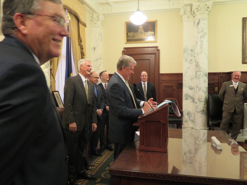 Gov. Butch Otter signs his first bill into law of the 2018 Idaho legislative session on Wednesday, Jan.n 31, 2018; at left is House Speaker Scott Bedke; at center, Senate President Pro-Tem Brent Hill. (Betsy Z. Russell)