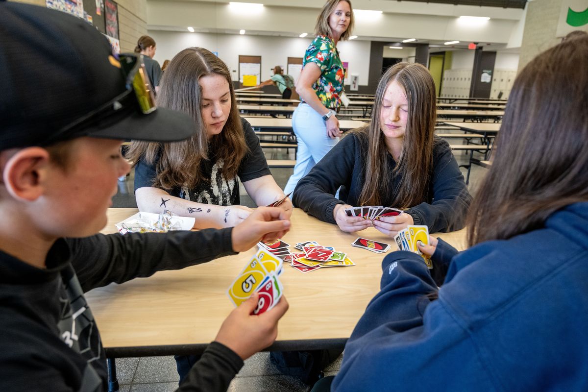 Salk Middle School Assistant Principal Sarah Pooler walks by a table of students playing Uno on their lunch break, left to right, Tyler Prosser, 14; Zoe Jackson, 13; Puniyo Hoard, 13; and Ofelia Gutierrez.  (COLIN MULVANY/THE SPOKESMAN-REVIEW)