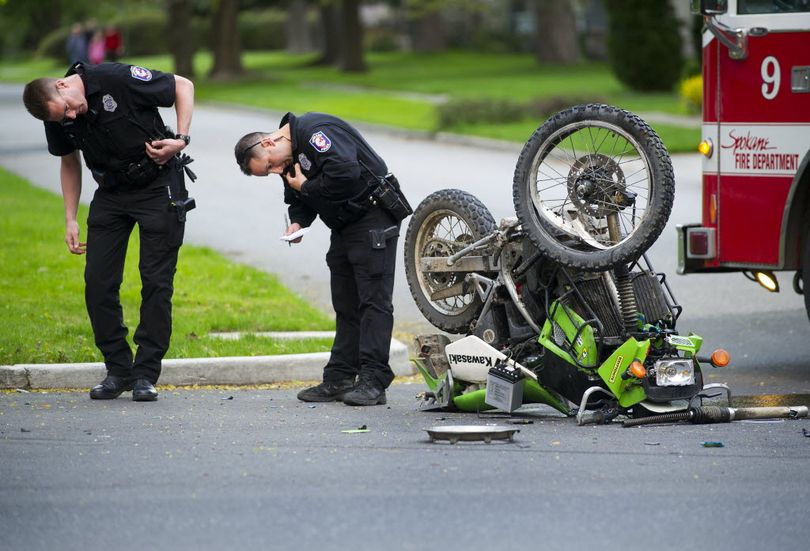 In this 2012 SR file photo, Spokane Police Department officers Chris Conrath, left and Micah Prim investigate a car verses motorcycle accident in the intersection of 21st Avenue and Lincoln Street. (Colin Mulvany / SR file photo)