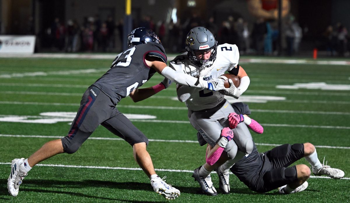 After a short pass, Mead wide receiver Johnny Talarico (2) runs the ball for a first down as Mt. Spokane defensive back Carson Kelly (23) and defensive back Hudson Buth move in for the tackle during the first half of a high school football game, Friday, October, 28, 2022, at Union Stadium in Mead.  (COLIN MULVANY/THE SPOKESMAN-REVIEW)