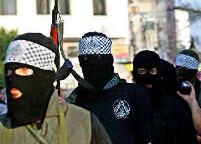 
Palestinian militants of the Al-Aqsa Martyrs Brigade march Monday to protest recent Israeli incursions. 
 (Associated Press / The Spokesman-Review)