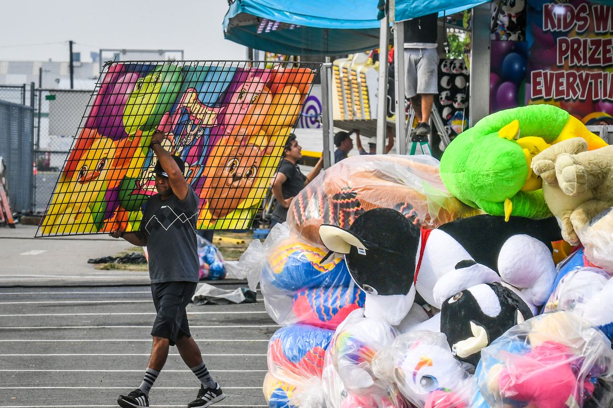 A  carnival worker assembles booths on Thursday, Sept. 9, 2021, before the start of the Spokane Interstate Fair on Friday.  (DAN PELLE/THE SPOKESMAN-REVIEW)