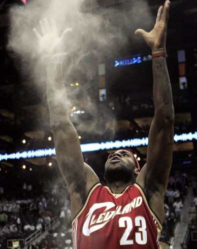 LeBron James throws rosin into the air as part of his pre-game ritual. (Associated Press / The Spokesman-Review)
