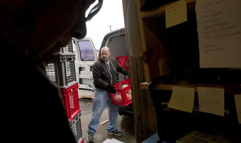 Community Action Partnership food bank volunteer Ken Battjer, center, unloads food from one of their vans at the facility in Coeur d’Alene on Thursday, Jan. 21, 2016. The food bank is raising money to replace two of the three vans, which range in age from 16 to 24 years old. (Kathy Plonka / The Spokesman-Review)