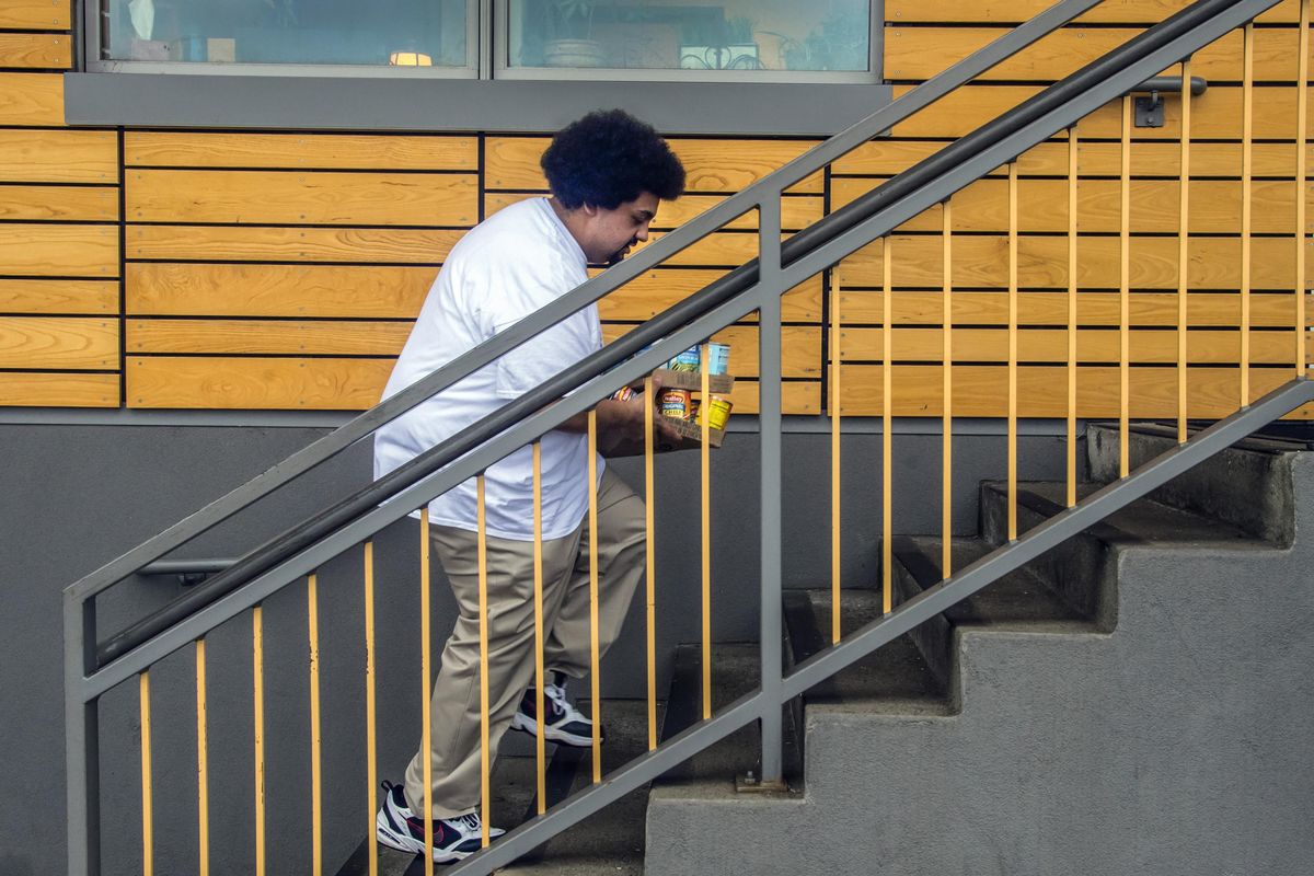 Sather Gowdy hauls flats of chili and green beans up the stairs to the Second Harvest Food Bank near Gonzaga University on Friday, Feb. 2, 2018. He paid about $79 for the canned goods at the Shadle Center Walmart. Gowdy, a Gonzaga law student, is on a mission to “heal Spokane” through acts of kindness and service. (Dan Pelle / The Spokesman-Review)