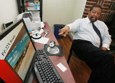
Thomas C. Settles, president and CEO of Omega Paving, shows off a computer promotion for the PZ-22X enzyme in his Atlanta office. Settles says the enzyme can toughen dirt roads and help them stand up better to rain. 
 (Associated Press / The Spokesman-Review)