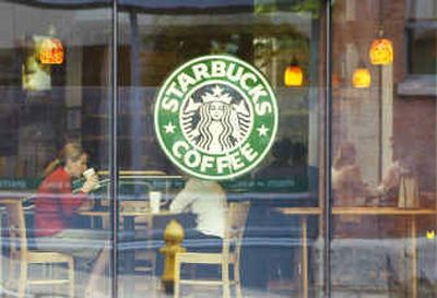 
Customers sit inside a Starbucks Coffee shop in downtown Seattle. Java junkies often must journey more than two blocks to find a Starbucks, which the company sees as a problem, its chief executive said Thursday. 
 (Associated Press / The Spokesman-Review)