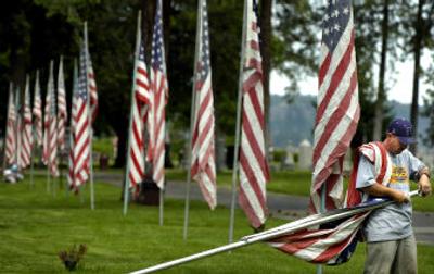 
Groundskeeper Ron Connor puts up American flags at Fairmont Memorial Park on Tuesday morning in preparation for Memorial Day. Each of the 2,164 flags was given in honor of a veteran who died and has the veteran's name on it. Each flag stands in the same place every Memorial Day. 
 (Holly Pickett / The Spokesman-Review)