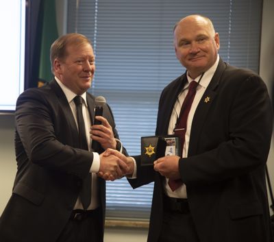 Former Spokane County Sheriff Ozzie Knezovich, right, receives his retired police badge, which will allow him certain special privileges after retirement from current Spokane County Sheriff John Nowels, left, Tuesday, Dec. 13, 2022, at the sheriff’s retirement party at the Spokane County courthouse. Knezovich announced Tuesday he is running for governor of his home state of Wyoming.  (Jesse Tinsley/THE SPOKESMAN-REVIEW)