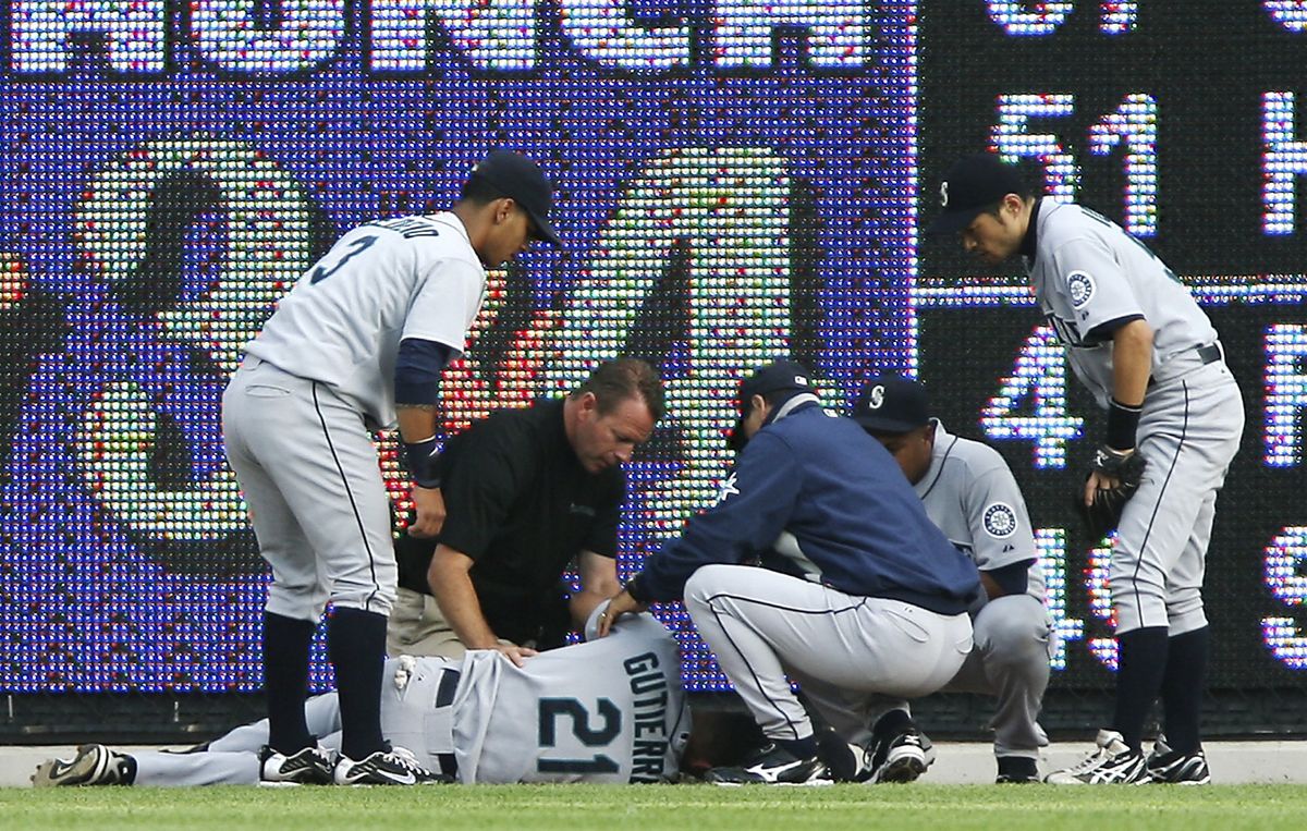 Franklin Gutierrez is examined after colliding with the scoreboard in right-center during the second inning against the Detroit Tigers. (Associated Press / The Spokesman-Review)