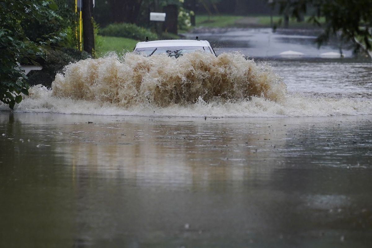 A car attempts to drive through flood waters near Peachtree Creek near Atlanta, as Tropical Storm Fred makes its way through north and central Georgia on Tuesday, Aug. 17, 2021.  (Brynn Anderson)