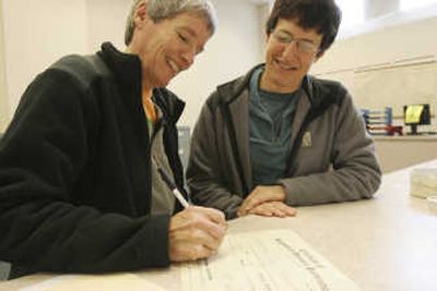 
Sherry Therens, left, and Cindy Flugum register their domestic partnership at the Marion County Clerks Office in Salem on Monday. Associated Press
 (Associated Press / The Spokesman-Review)