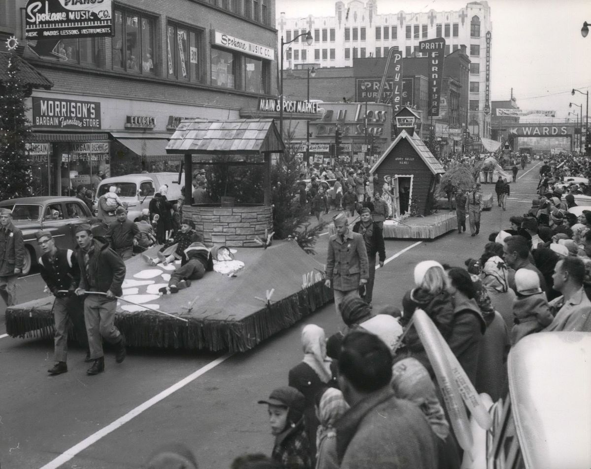 1957: Boy Scouts pull parade floats along Post Street south of Main Avenue during the Christmas parade on the Friday after Thanksgiving. The float at left has a “Jack and Jill” theme, followed by “Mary Had a Little Lamb” and others of the six floats based on nursery rhymes, paid for by downtown merchants through the Spokane’s Retail Trade Bureau, which started as an arm of the Chamber of Commerce. Today, the work to promote retail business, cleanup of streets and sidewalks, and adding holiday lights and decorations is handled by the Downtown Spokane Partnership, the business improvement district supported by taxes paid by area businesses.  (Spokesman-Review photo archives)