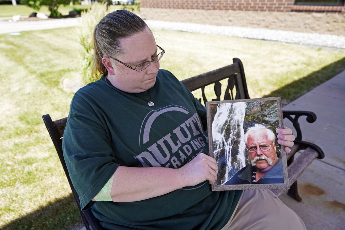 Ann Haas poses on June 18 in Eden Prairie, Minn., with a photo she took of her late father, Raymond Haas.  (Jim Mone)